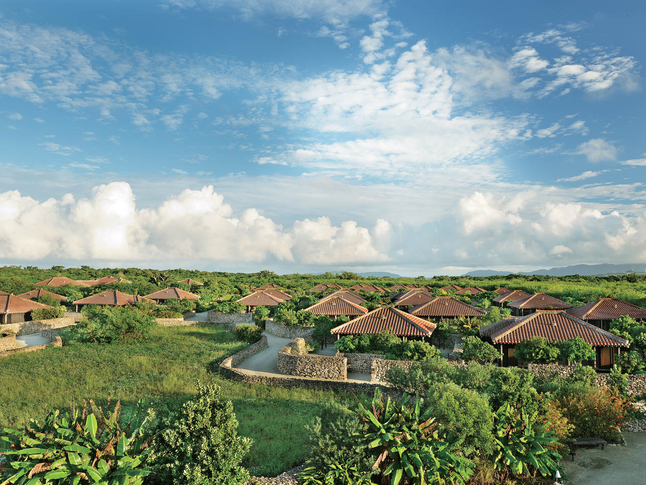 グックに囲まれた、琉球赤瓦屋根の客室がたたずむ星のや竹富島。2012年のオープンから7年が経ち、木々が成長し、グックも黒ずみ、島の風景に一層なじんでいる
