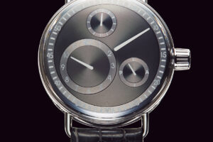 シリーズ1 レッセンスの記念碑的なデビュー作。リュウズだけで13の部品から構成されており、時刻合わせはリュウズトップのバーを起こして行う。ループ状のラグはケースと別パーツであるため、ストラップの取り外しには専用工具が必要。自動巻き、ケース径44㎜、SSケース×クロコダイルストラップ、1,728,000円。