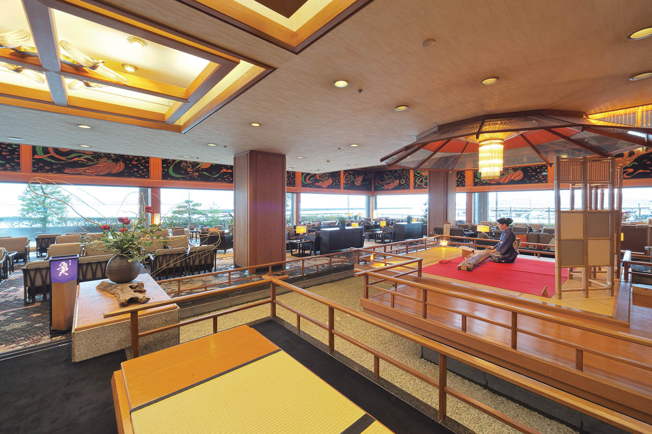 ゲストを迎えるラウンジ「飛天」は、天女が舞う輪島塗の大パネルが印象的な豪華な空間で、舞台の上からは琴の生演奏が響く